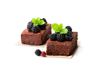 Chocolate  brownie pieces with blackberries isolated on white