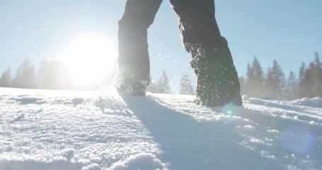 Person walking in high snow on a beautiful snowy day in slow motion