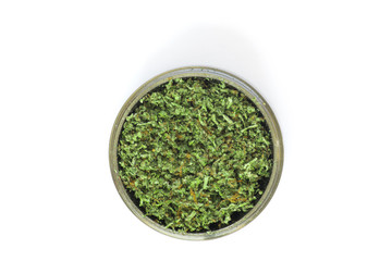grinder with Crushed buds of marijuana, weed cannabis isolated on white background