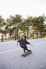 Beautiful young girl riding longboard.