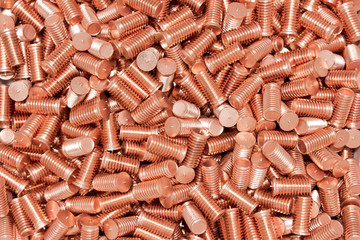 Pile of threaded copper metal screw bolts