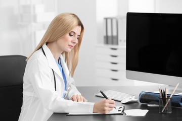 Female doctor filling up application form in consultation room