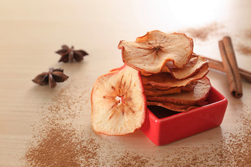 Tasty apple chips on table