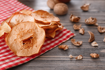 Tasty apple chips on wooden table