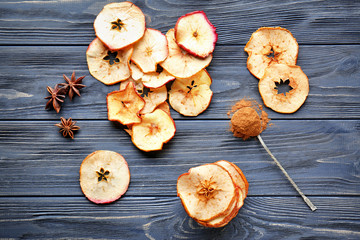 Composition with tasty apple chips on wooden background, top view