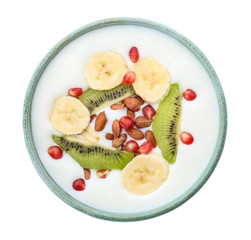 Yogurt with banana, pomegranate seeds and kiwi in dish on white background