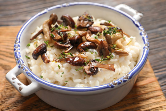 Dish with risotto and mushrooms on wooden board