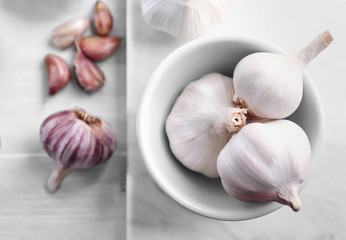 Bowl with fresh garlic on board