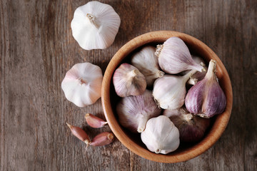 Bowl with fresh garlic on wooden table