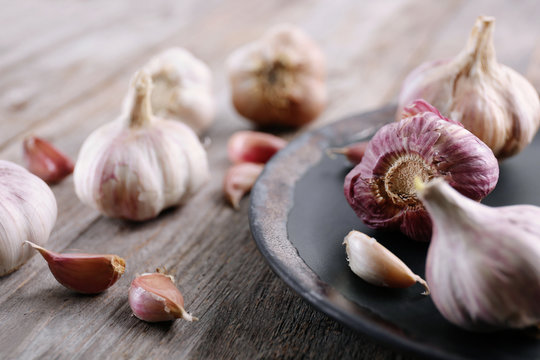 Fresh garlic with plate on wooden table