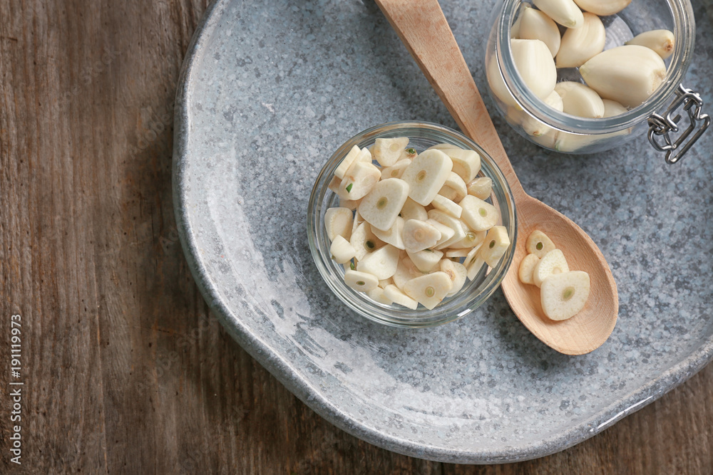 Canvas Prints Bowl with chopped garlic and cloves in jar on plate