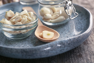 Bowl and spoon with chopped garlic on plate