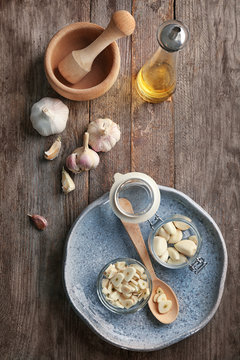 Garlic and kitchen utensils on wooden background