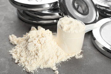 Protein powder and measuring scoop on table