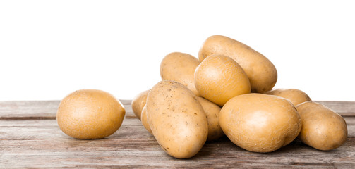 Fototapeta na wymiar Fresh raw potatoes on wooden table against white background