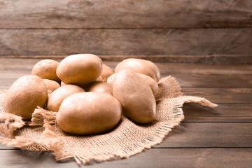 Fresh raw potatoes on wooden table