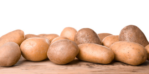 Fototapeta premium Fresh raw potatoes on wooden table against white background