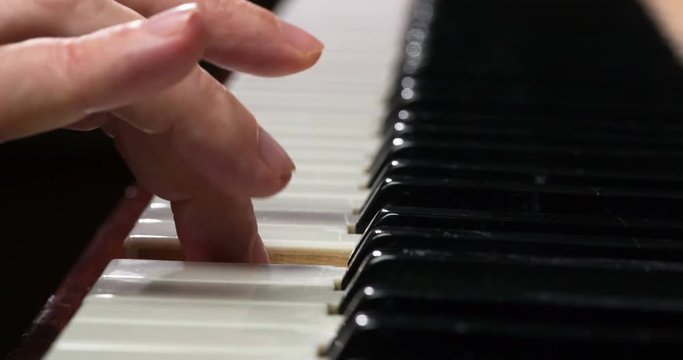 Slow Touching the Piano Keys. Male fingers close-up slowly touch the piano keys, extracting a simple melody. Filmed at a speed of 120fps