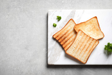 Tasty toasted bread on marble board