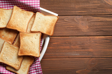 Tasty toasted bread in tray on wooden table