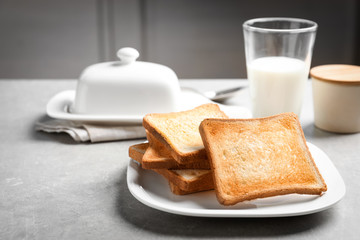 Fototapeta na wymiar Plate with tasty toasted bread on table
