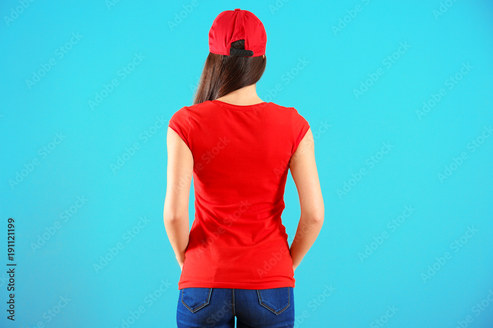 Wall mural Beautiful young woman in red t-shirt on color background. Mockup for design