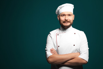 Naklejka premium Handsome male chef on color background