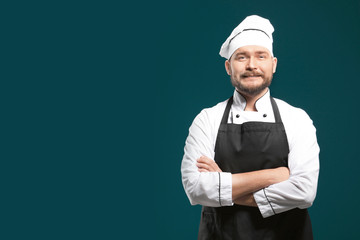 Handsome male chef on color background