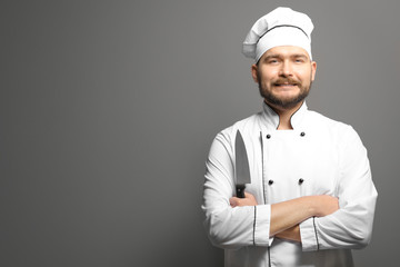 Handsome male chef on gray background