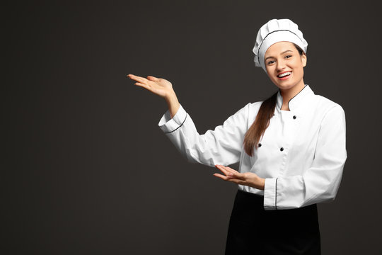Beautiful female chef on dark background