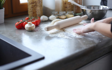 Beautiful woman cooking cake in kitchen standing near desk.