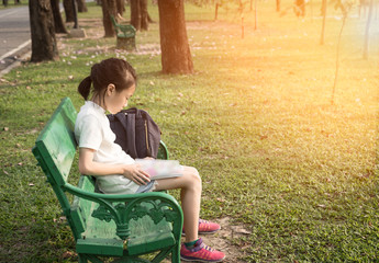 Asian girl reading a book in the park