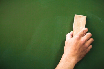 Right of hands holding using  brush erasing on blackboard,Education concept.