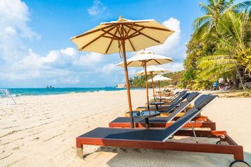 Obraz na płótnie Canvas Umbrella and chair on the beach and sea