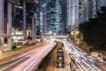 Traffic rushing in Hong Kong island while a tram car wait.