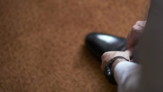 man in a suit tying shoes