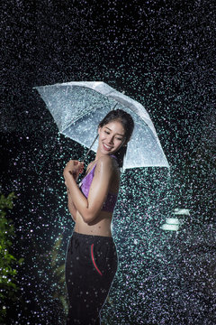 Young woman with umbrella under the autumn shower.