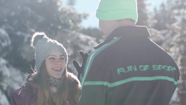 Young woman stealing her boyfreind's hat and running away