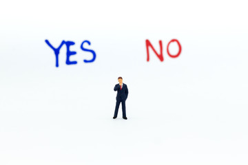 Miniature people: Businessman stand with 'YES or NO' word, pathway choice. Image use for business decision concept, new the way.