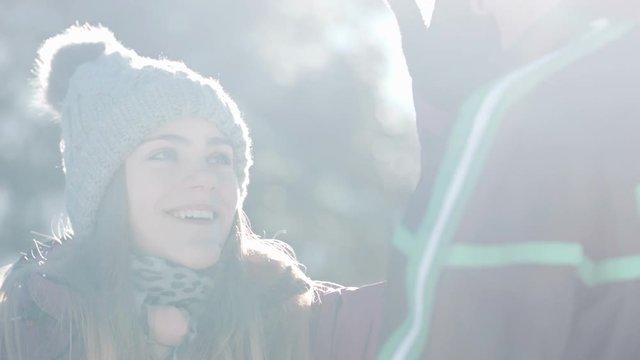 Close up of young woman stealing her boyfreind's hat and running away