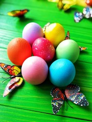 multicolored eggs on wooden green background
