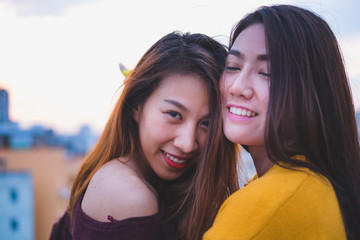 Two asia lesbian lgbt couple at roof top party in sunset evening time,love wins concept,enjoy and cheerful lifestyle.