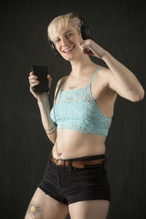 Happy young woman in shorts, dancing with headphones on.