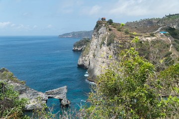 Rock in the ocean at Atuh beach on Nusa Penida island, Indonesia. Rocks in a blue sea lagoon with breaking waves. Travel concept