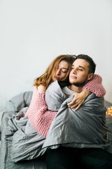 Cute couple wasting their time in cozy bed. Soft focus. Artwork