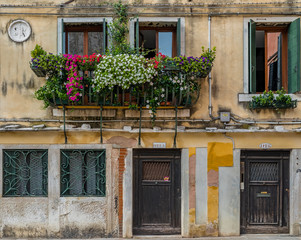 Fototapeta na wymiar Exterior of an old building with shutters and ornate windows in Venice Italy