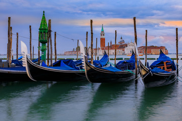 Fototapeta na wymiar Gondolas along Grand Canal at St Marco square with San Giorgio Maggiore church at sunrise in Venice Italy