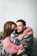 Cute Young Woman Embracing Her Boyfriend. Young couple in love hugging on the bed. Soft focus