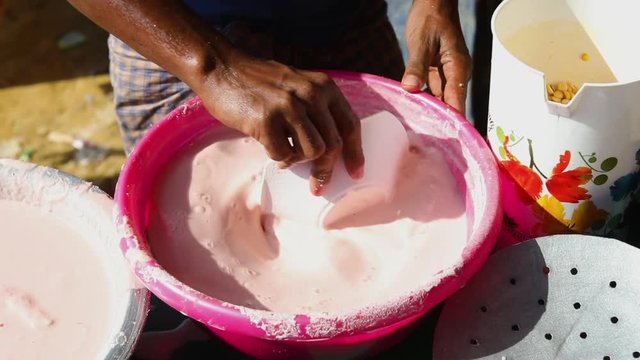 Young man in a farmer's market mixes up a milky liquid