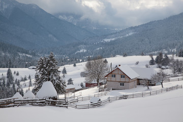 winter in the mountains - small Romanian village in the Carpathians covered with snow
